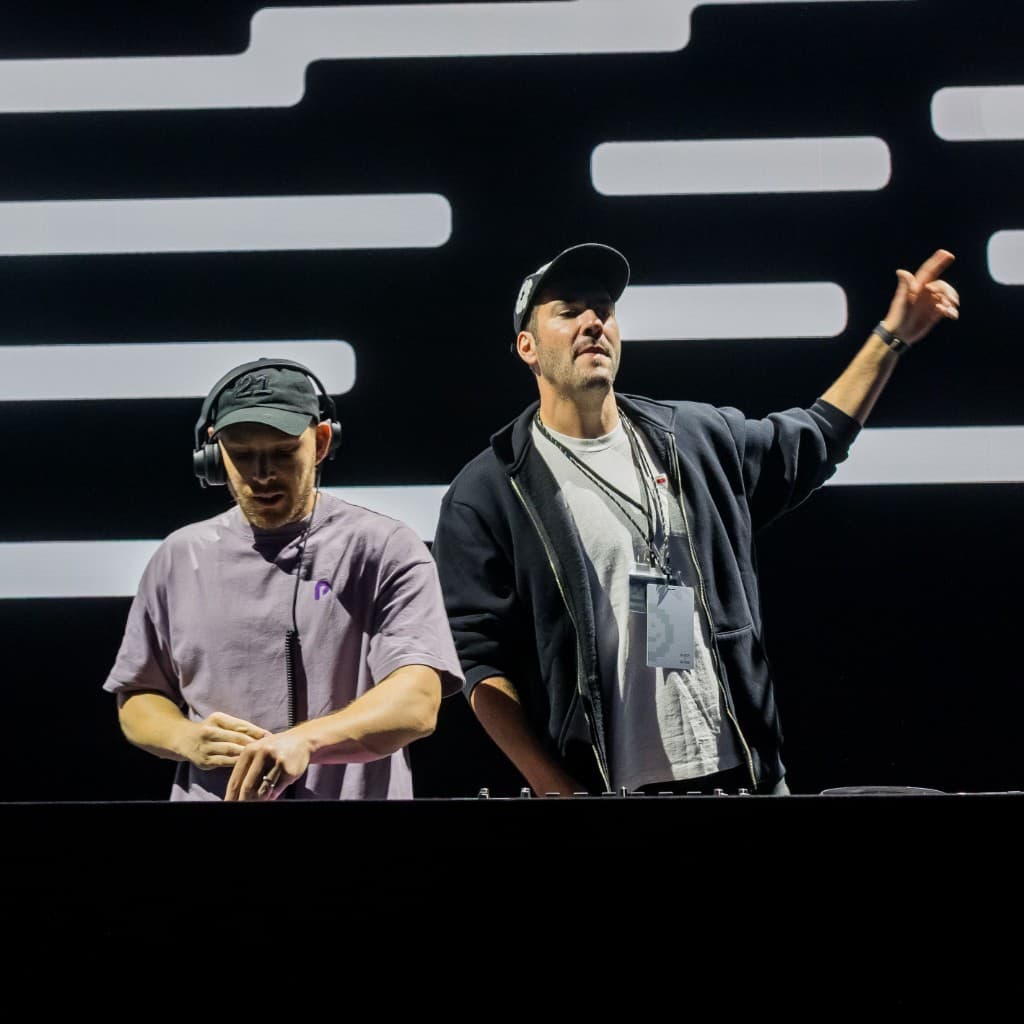 Jamie Selects DJing beside another DJ at Block x Block, one arm raised toward the crowd